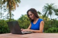 Cheerful girl watching online video on laptop computer sitting in the park Royalty Free Stock Photo