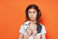 cheerful girl in a white t-shirt in headphones with a joystick in hands playing entertainment