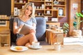 Cheerful girl working with tablet computer in coffee shop Royalty Free Stock Photo