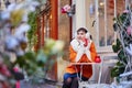 Cheerful girl writing Christmas cards in cafe