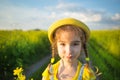 A cheerful girl in a yellow hat in a summer fiel. Children`s day, joy, sunny weather, holidays. A remedy for mosquitoes and Royalty Free Stock Photo