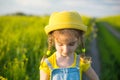 A cheerful girl in a yellow hat in a summer fiel. Children`s day, joy, sunny weather, holidays. A remedy for mosquitoes and Royalty Free Stock Photo