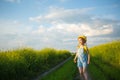 Cheerful girl in a yellow hat in a summer field laughs and smiles. Joy, sunny weather, holidays. A remedy for mosquitoes and Royalty Free Stock Photo