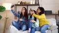 Cheerful girls sitting at home and live streaming using smartphone