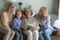 Cheerful girls and women congratulating eldest great grandma on birthday