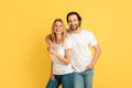 Cheerful glad millennial caucasian male hugging blonde lady in white t-shirts, looking at camera Royalty Free Stock Photo