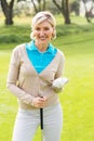 Cheerful golfer smiling at camera holding her club Royalty Free Stock Photo