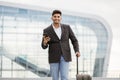 Arabian man going to the business trip with his luggage, standing outdoors at airport Royalty Free Stock Photo