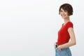 Cheerful good-looking happy healthy young smiling girl short pixie haircut standing profile turn camera amused