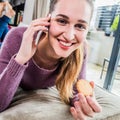 Cheerful gorgeous girl with a cookie talking on her phone