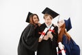 Cheerful graduate classmates celebrating smiling rejoicing over white background.