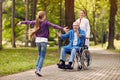 Cheerful grandchildren visiting disabled father in park