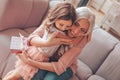 Cheerful granddaughter hugging her grandmother with present in the hand at home Royalty Free Stock Photo