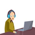 A cheerful grandmother sitting at a table with headphones uses a laptop for online communication