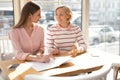 Cheerful granny family discussing business with her granddaughter