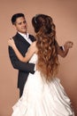 Cheerful Groom and bride dansing wedding dance isolated on beige Royalty Free Stock Photo