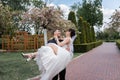 Cheerful groom holding on hands bride