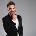 Cheerful groom holding his hand on his chin and laughing