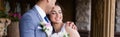 Cheerful groom hugging bride with closed