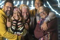 Cheerful group caucasian family all together celebrating the new year eve posing for a picture - happy adults and senior with a Royalty Free Stock Photo