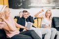 Cheerful group of friends eating popcorn at home