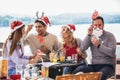 Group of friends having fun in cafe holding artificial mustache and lips stick