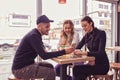 Young man and two women sitting at the table in the cafe shop Royalty Free Stock Photo