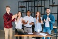 Cheerful group of multi-ethnic business people applauding and smiling gratefully looking into camera Royalty Free Stock Photo