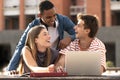 Cheerful group of people working together with a laptop in campus.Young multiracial friends studying and laughing Royalty Free Stock Photo