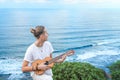Cheerful guitarist strumming acoustic guitar on coastline Royalty Free Stock Photo