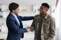 Cheerful guy in suit shaking black military man hand Royalty Free Stock Photo