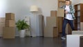 Cheerful guy coming with paper box to his new rented apartment, real estate