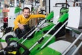 cheerful guy deciding on best lawnmower in garden equipment shop