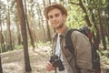 Cheerful guy is enjoying walk in woodland