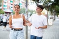 Cheerful guy trying to pick up young stranger girl on city street