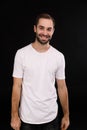 Cheerful guy in a white T-shirt on a black background Royalty Free Stock Photo