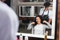 Cheerful hairstylist in apron looking at