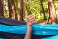 Cheerful hand in a hammock at the forest. outdoor travel concept image