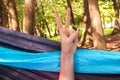 Cheerful hand in a hammock at the forest. outdoor travel concept image