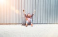 Cheerful hands rising UP Beautiful modern smiling young female teenager in a checkered shirt and jeans with headphones and