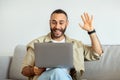 Cheerful handsome guy using laptop at home, have video call Royalty Free Stock Photo