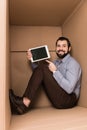 cheerful handsome man pointing at tablet with html code while sitting