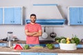 Cheerful handsome man standing with crossed hands in modern kitchen, vegan nutrition, healthy diet