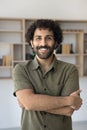 Cheerful handsome young Arab entrepreneur guy posing indoors