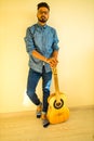 Cheerful handsome young man playing guitar and smiling in new cozy apartment Royalty Free Stock Photo