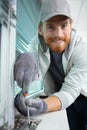 cheerful handyman installing window shutters Royalty Free Stock Photo