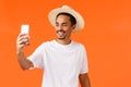 Cheerful happy african-american guy taking selfie on vacation under sun near sandy beautiful beach tropical island Royalty Free Stock Photo