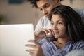 Cheerful happy African American young marriage laughing while watching movie on laptop computer at home interior. Royalty Free Stock Photo