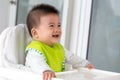 Cheerful happy Asian baby waiting to eat food and sitting