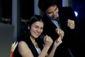 Cheerful happy Asian staff officer business man and woman reaching hands up to celebrate after finishing working-hard overtime